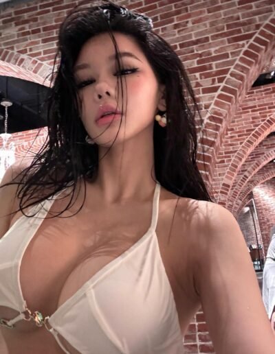 Gorgeous escort with long black hair posing elegantly, highlighting her curvy figure.
